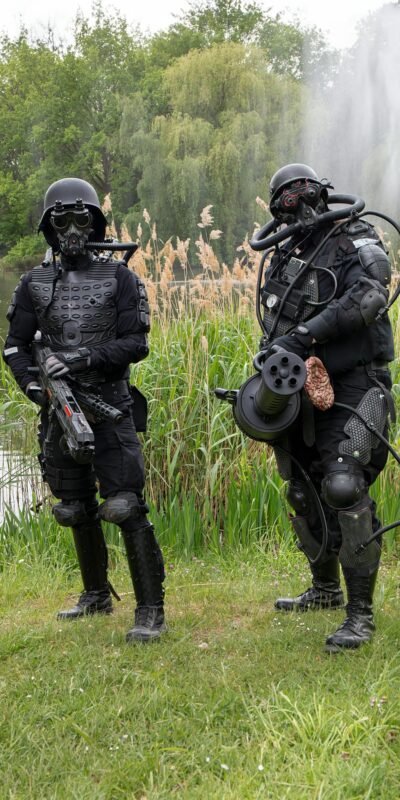 Two soldiers in high-tech gear stand by a pond with a fountain in Leipzig, Germany.